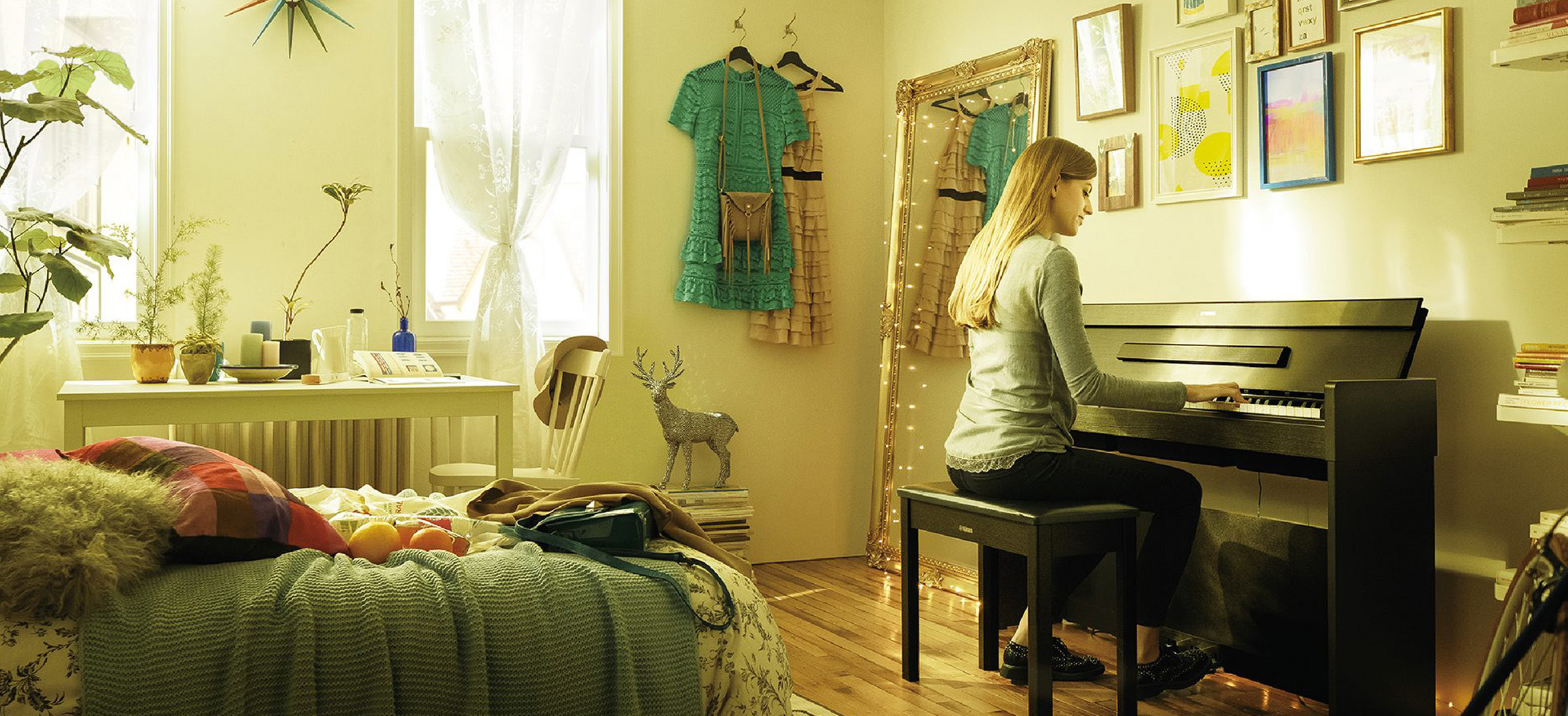 Photo of a young woman playing the YDP-S34 in their studio bedroom