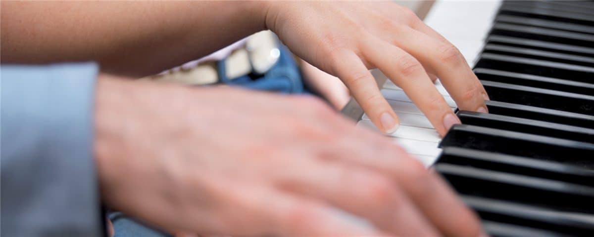 Child hands learning to play piano